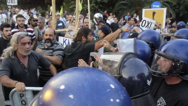 Demonstrators scuffle with the police outside parliament in Nicosia, as MPs approved the bailout.