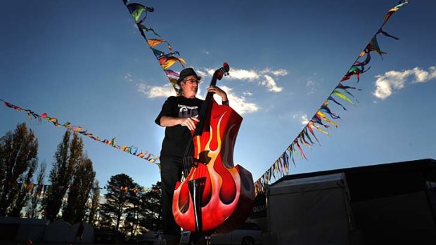 Setting the tone ... instrument maker David Guscott, from Toowoomba, tunes up his double bass at the National Folk Festival in Canberra yesterday.