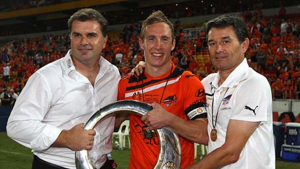 Ange Postecoglou holds the winners trophy with Matthew Smith and assistant coach Rado Vidosic after the 2012 A-League Grand Final match.