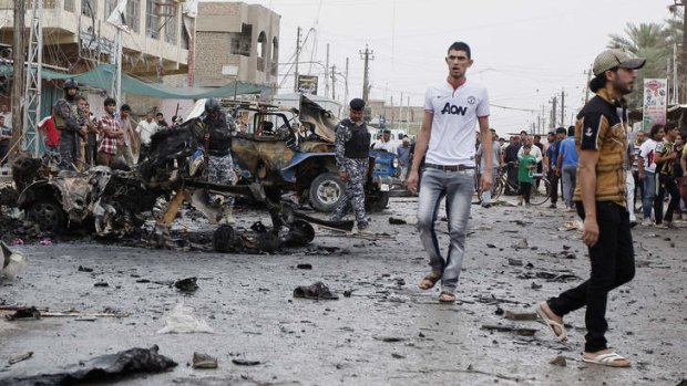 Wave of bombings: Iraqi security forces and civilians inspect the scene of a car bomb attack in the Kamaliya neighbourhood of Baghdad.