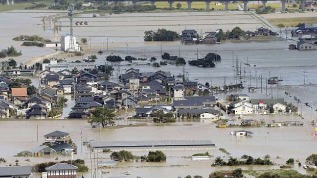 An aerial view shows residential areas flooded by the Yura river in Fukuchiyama, Kyoto prefecture.