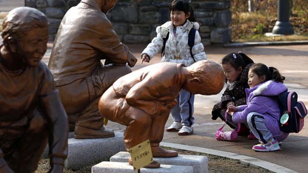 Kindergarden children look at a statue of a Korean boy responding to the call of nature at the Toilet Culture Park in Suwon.