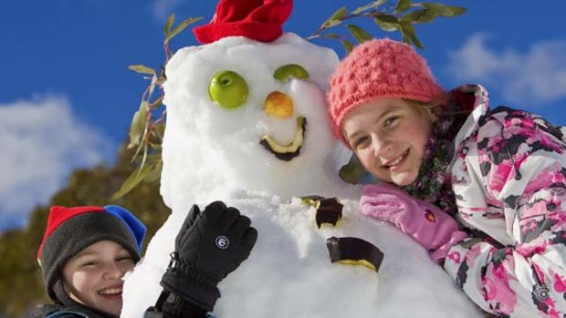 Cool fun ... children finesse their snowman.