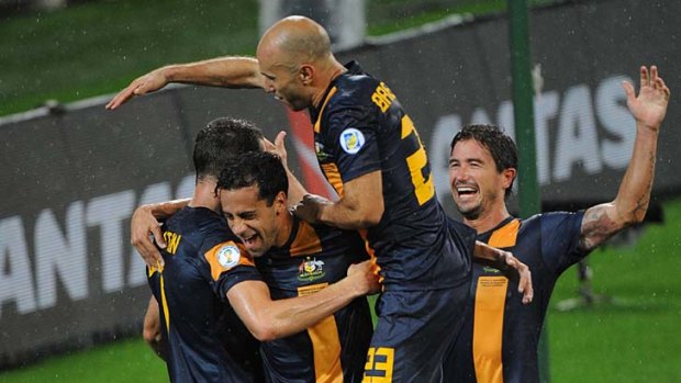 Goal! Alex Brosque is mobbed by teammates including Mark Bresciano and Harry Kewell.
