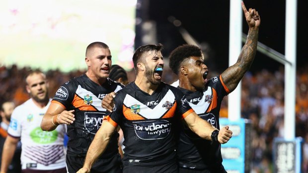 Fired up: Teammates mob James Tedesco after his third try.