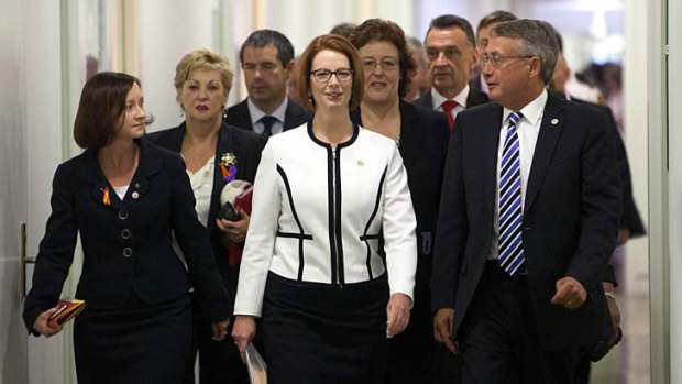 Day of reckoning: Julia Gillard, Wayne Swan and team emerge from caucus after a hugely costly victory.