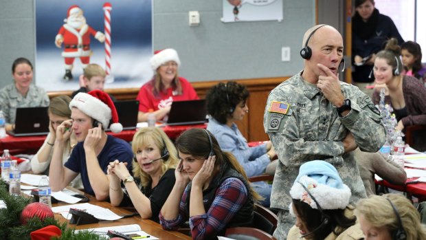 NORAD Chief of Staff Major General Charles Luckey joins other volunteers taking phone calls from children around the world asking where Santa is. Central command is at Peterson Air Force Base, Colorado