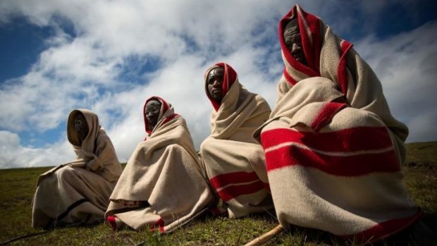 Old ways: Xhosa youths sit on a hillside overlooking Qunu before his funeral cortege arrives.