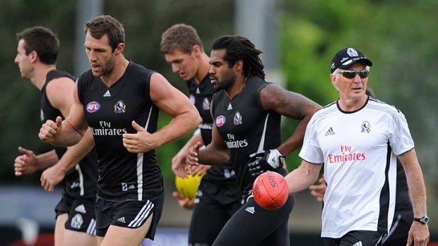 Speculation builds that Mick Malthouse, pictured with Collingwood players Travis Cloke (second from left) and Harry O'Brien (second from right), will remain as coach if the Pies wins back-to-back flags.