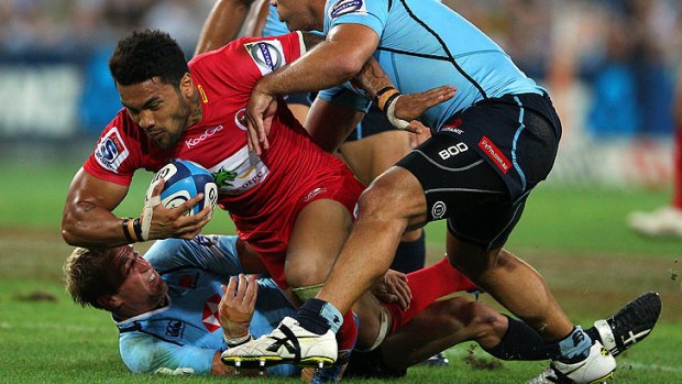 Queensland Reds winger Digby Ioane is pulled down against the New South Wales Waratahs in Sydney in February.