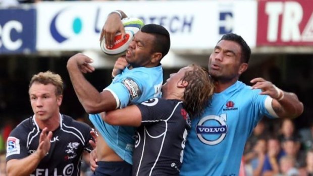 Kurtley Beale is held up by Charl McLeod of the Sharks during the Super Rugby match in Durban.