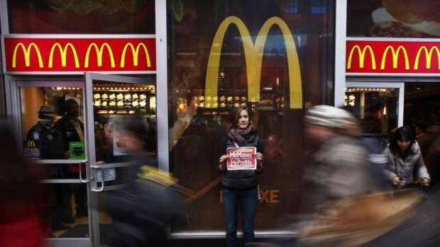 A protester holds up a poster in front of a McDonald's restaurant in Times Square, New York.