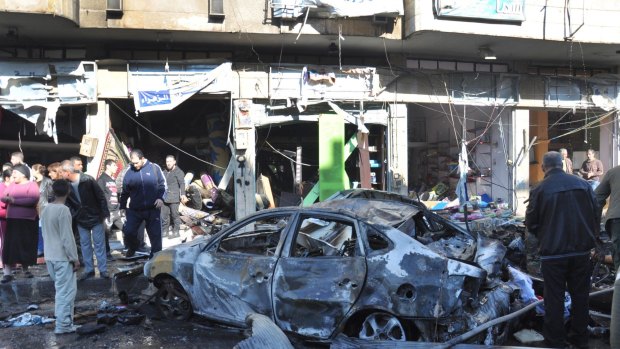 Syrian citizens gather at the scene where twin bombs exploded in the government-held neighbourhood of Zahra, in Homs province, central Syria, on Monday.