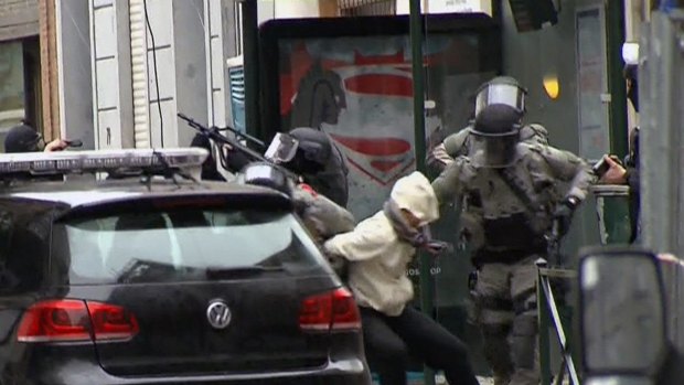 The moment Salah Abdeslam is bundled into a car by police.