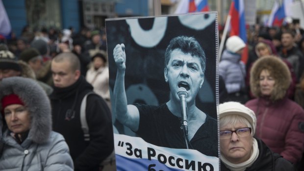 A demonstrator holds a poster reading "For Russia without Putin" as part of a march to commemorate the slaying of opposition leader Boris Nemtsov.
