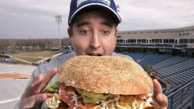 Josh Kowalczyk, an intern with the West Michigan Whitecaps, sizes up the monster burger.