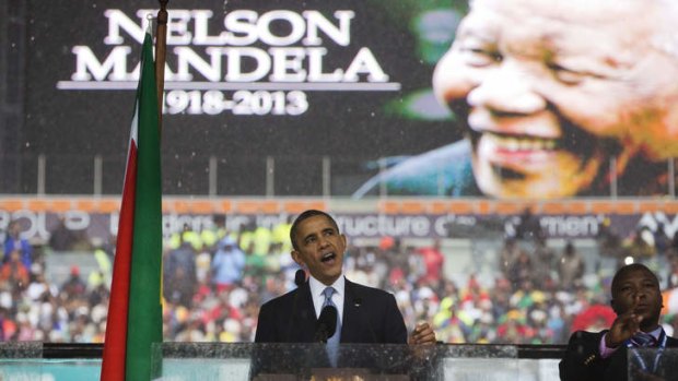 "He changed laws, but he also changed hearts" ... President Barack Obama speaks to crowds attending the memorial service for former South African president Nelson Mandela at the FNB Stadium.