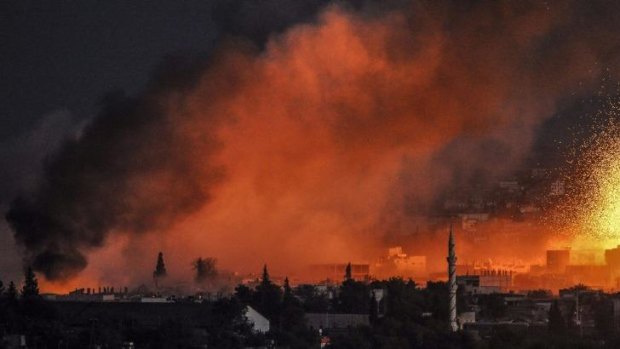 Under fire: Smoke and flames rise following an explosion in the Syrian town of Kobane.