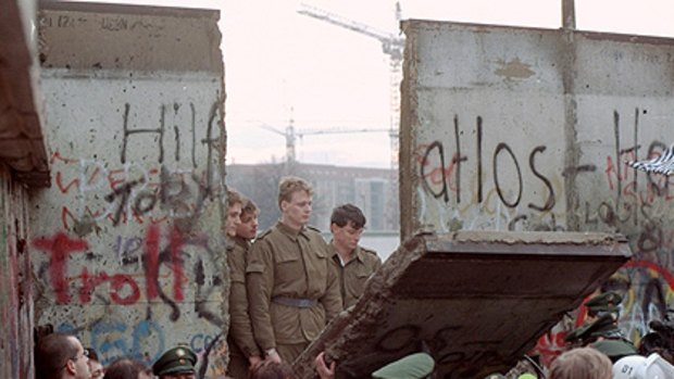Flashback to November 1989 ... East German border guards look through a hole in the Berlin wall after demonstrators pulled down a segment of  at Brandenburg gate.