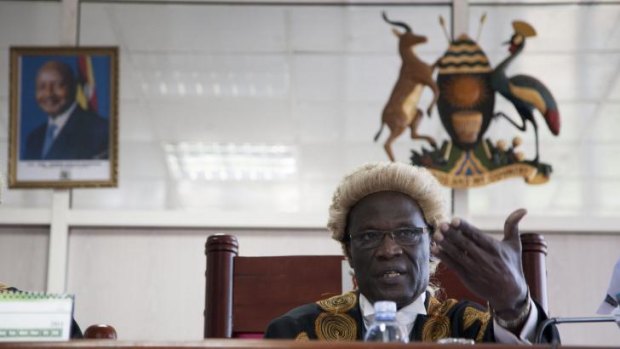 A picture of Uganda's president hangs on the wall behind judge Stephen Kavuma as he reads the verdict.