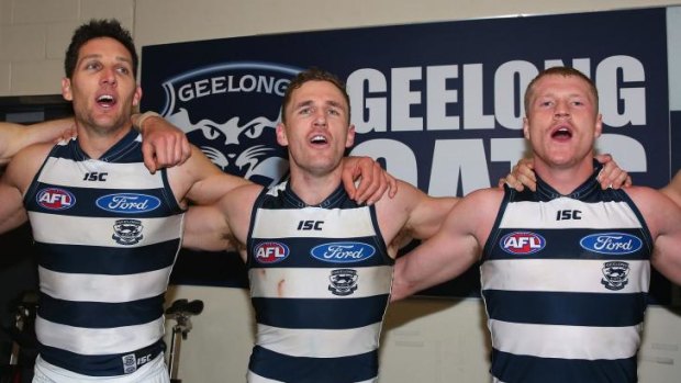 Harry Taylor, Joel Selwood and Josh Caddy sing the club song in the rooms after Geelong's victory on Friday night.