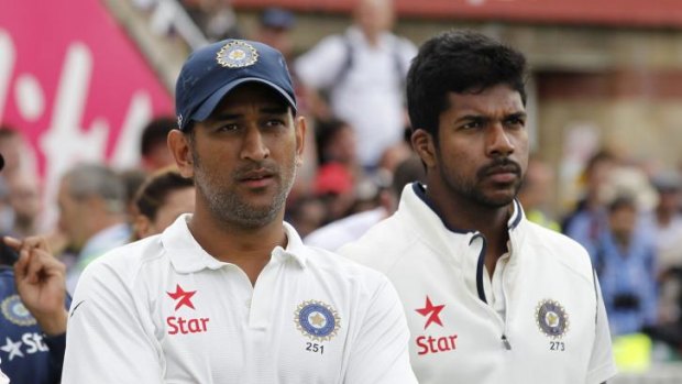 India's captain and wicketkeeper  Mahendra Singh Dhoni (L) and India's Varun Aaron.