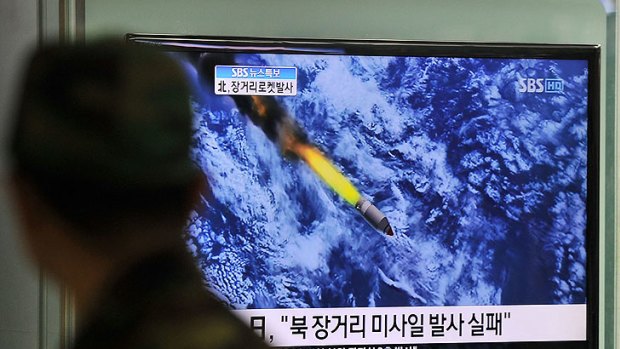 A South Korean man watches a TV screen showing a graphic of North Korea's rocket launch at a train station in Seoul.