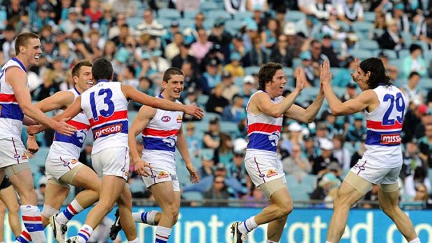 Hat-trick: Dogs debutant Jason Tutt (centre) celebrates his third goal from only his third kick in the AFL.