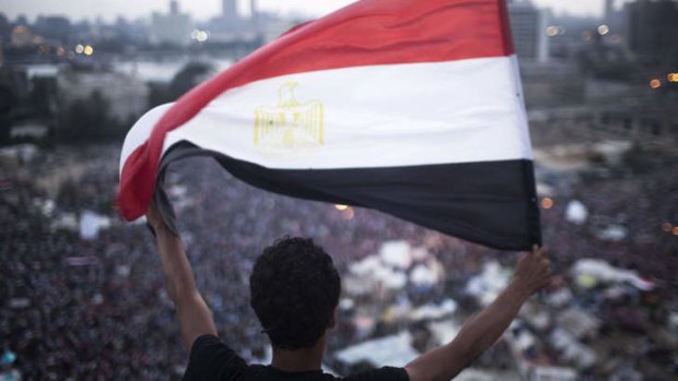 An Egyptian protester waves a flag in the turmoil of Tahrir Square.
