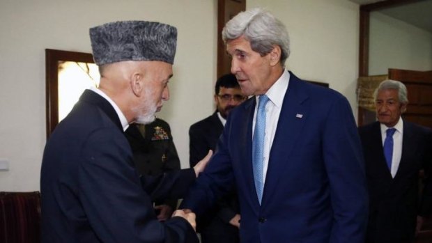 US Secretary of State John Kerry is greeted by Afghanistan's President Hamid Karzai as he arrives for a dinner at the presidential palace in Kabul on Friday.