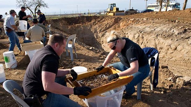 Sheriff detectives Paul Hoskins, left, and Lindsay Smith sift for human remains that were excavated from an abandoned cattle ranch.