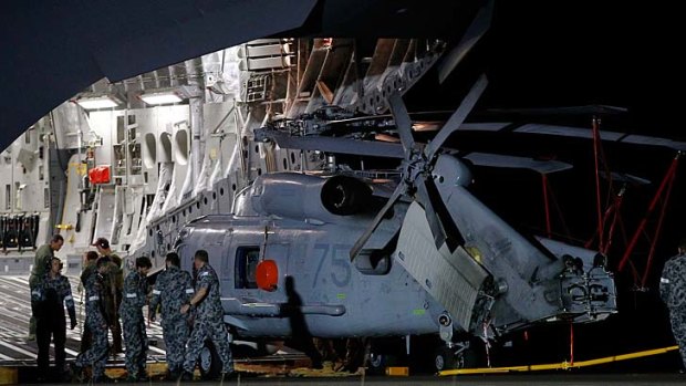 A Navy Seahawk helicopter is offloaded from a RAAF C17 Globemaster aircraft.