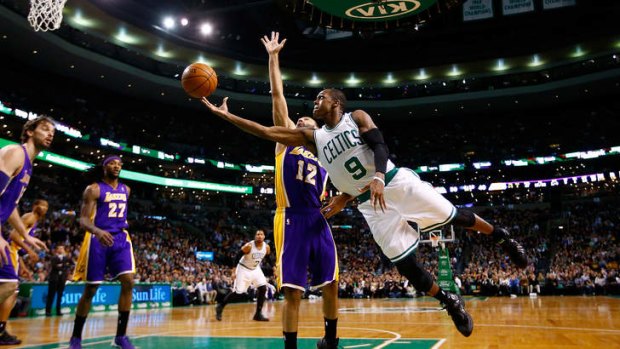 Boston Celtics guard Rajon Rondo is midair for a layup in front of Lakers opponent Kendall Marshall during the Lakers' narrow win at TD Garden.