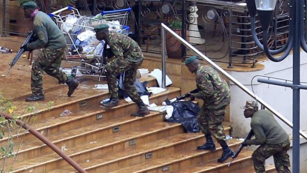 Kenyan soldiers take up positions at the Westgate shopping centre on Tuesday as security forces searched for militants still holed up in the complex.