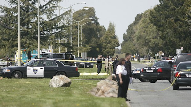 Police stand guard over an area where two people are believed to have died.