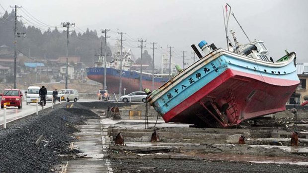 Vehicles, pictured on March 8, 2012, move among fishing vessels that were carried from Kesennuma port by the March 11, 2011 tsunami in Miyagi prefecture.