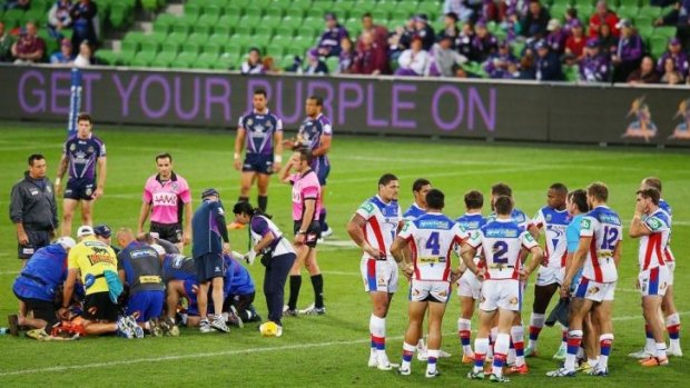 Grim viewing: McKinnon was treated on the field for five minutes in Melbourne on Monday night as his teammates looked on. He was later taken to hospital.