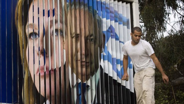 Once were enemies ... A worker walks next to a rotating sign showing former Kadima Party leader Tzipi Livni, left, and Likud Party leader Benjamin Netanyahu in Tel Aviv in 2009.