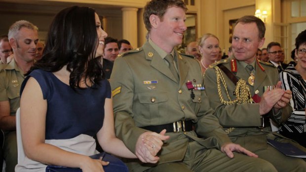 Corporal Daniel Keighran's hand is held by his wife Kathryn after he was awarded the Victoria Cross by Governor-General Quentin Bryce at Government House today.