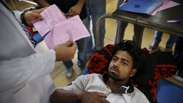 A doctor looks at the blood report of a patient suffering from dengue fever at a government hospital in New Delhi, India on Thursday.