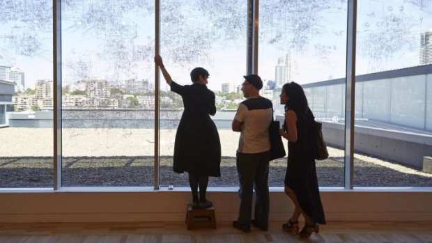 Performative drawing: Gosia Wlodarczak (left) drawing directly onto a window at the AGNSW overlooking the landscape of Woolloomooloo for the Dobell Australian Drawing Biennial 2014 at the AGNSW, with Michael Harding and Lily Lui.