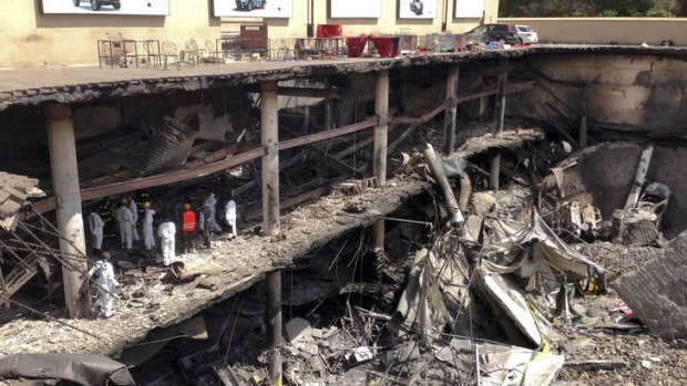 Picking up the pieces: Forensics investigators work next to the collapsed upper car park at the Westgate Mall in Nairobi.