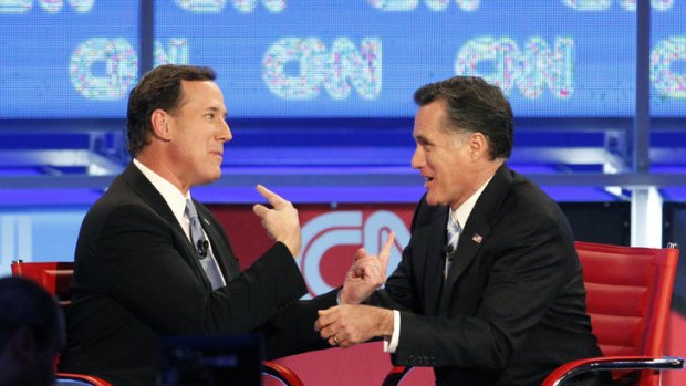 Rick Santorum (left) and Mitt Romney talk after their presidential race debate in Mesa, Arizona.