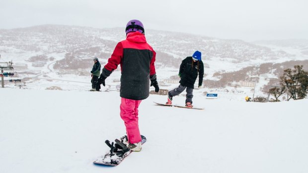 Some snowboarders at play during the snowfall at Perisher on Saturday.