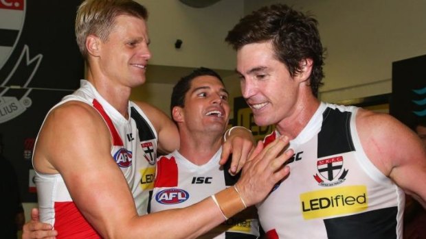 Nick Riewoldt, Leigh Montagna and Lenny Hayes celebrate in the rooms after defeating Essendon on Saturday.