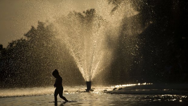 A child cools off in a fountain at the Temple of Debod park during a day where temperatures reached 37 degrees in Madrid.