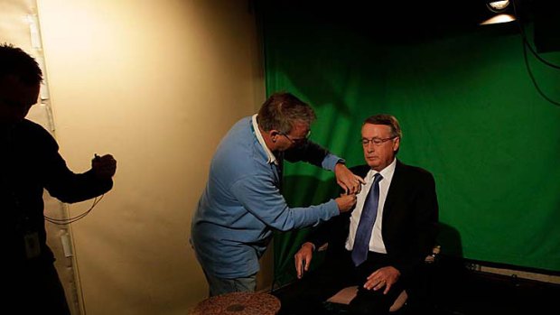 Treasurer Wayne Swan gets ready for a television interview at Parliament House yesterday.
