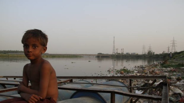 Amid the foul stench of the riverbank, a young "ragpicker" sits near the detritus of one of India's most polluted waterways.