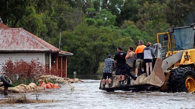 To the rescue ... residents of Skipton near Ballarat rush to sandbag a house.