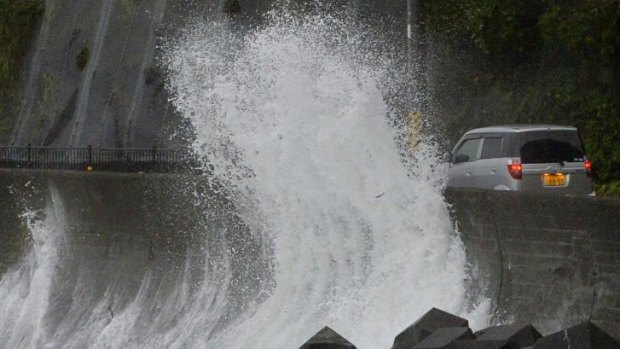 A huge sea wave hit against a concrete wall to a road in Kushimoto, western Japan.